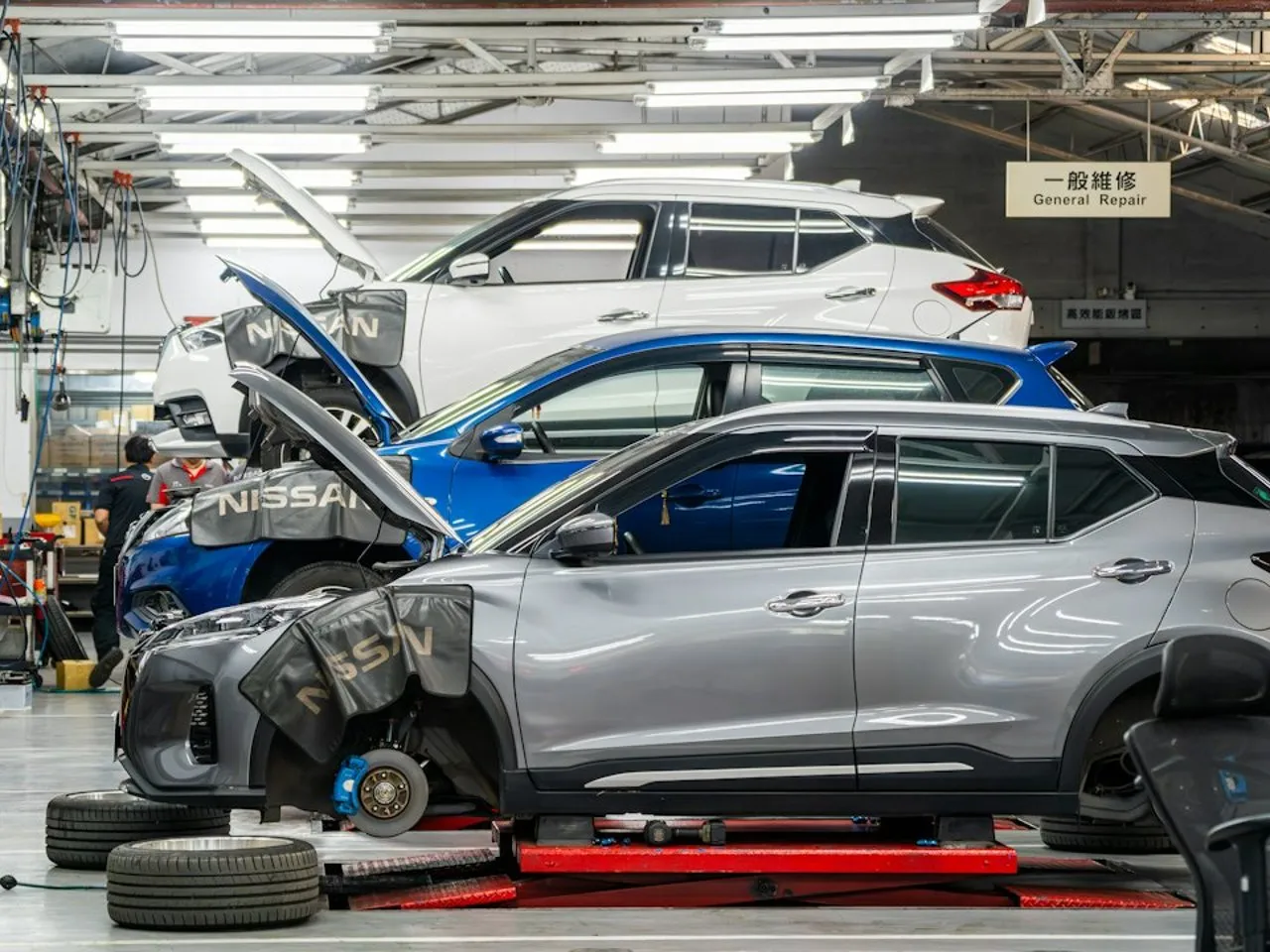 Vue d'atelier avec turbos et injecteurs diesel reconditionnés alignés sur un établi, éclairage industriel.